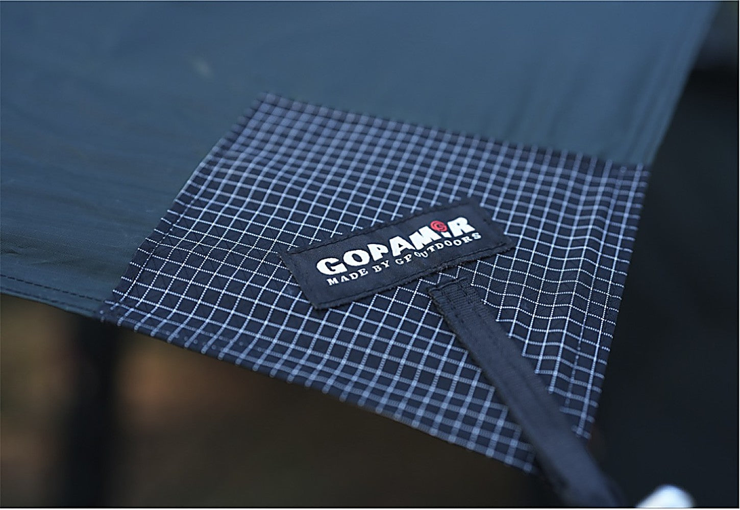 Close-up of Gopamir label on the ripstop reinforcement patch of the black-coated T720+ Side Tarp