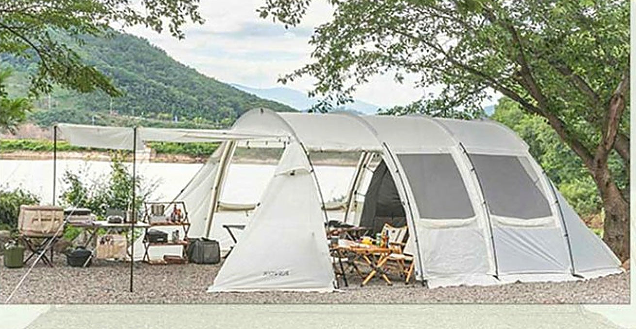 Monster tunnel tent with front vestibule and awning extended at a riverside campsite
