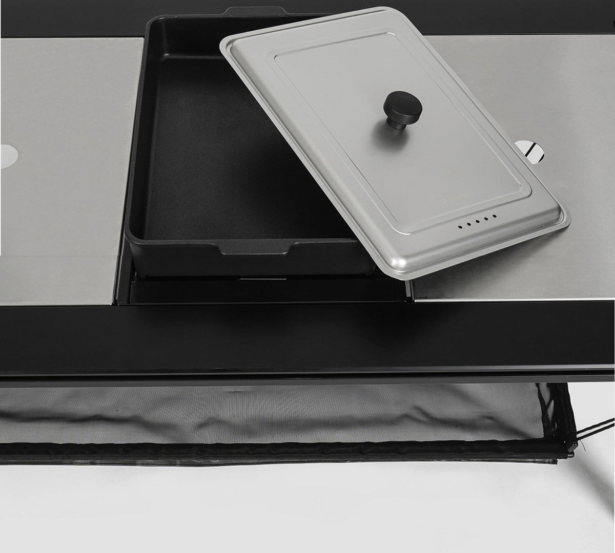 Stainless steel hot pot pan cover resting on the hot pot pan beside the grill top