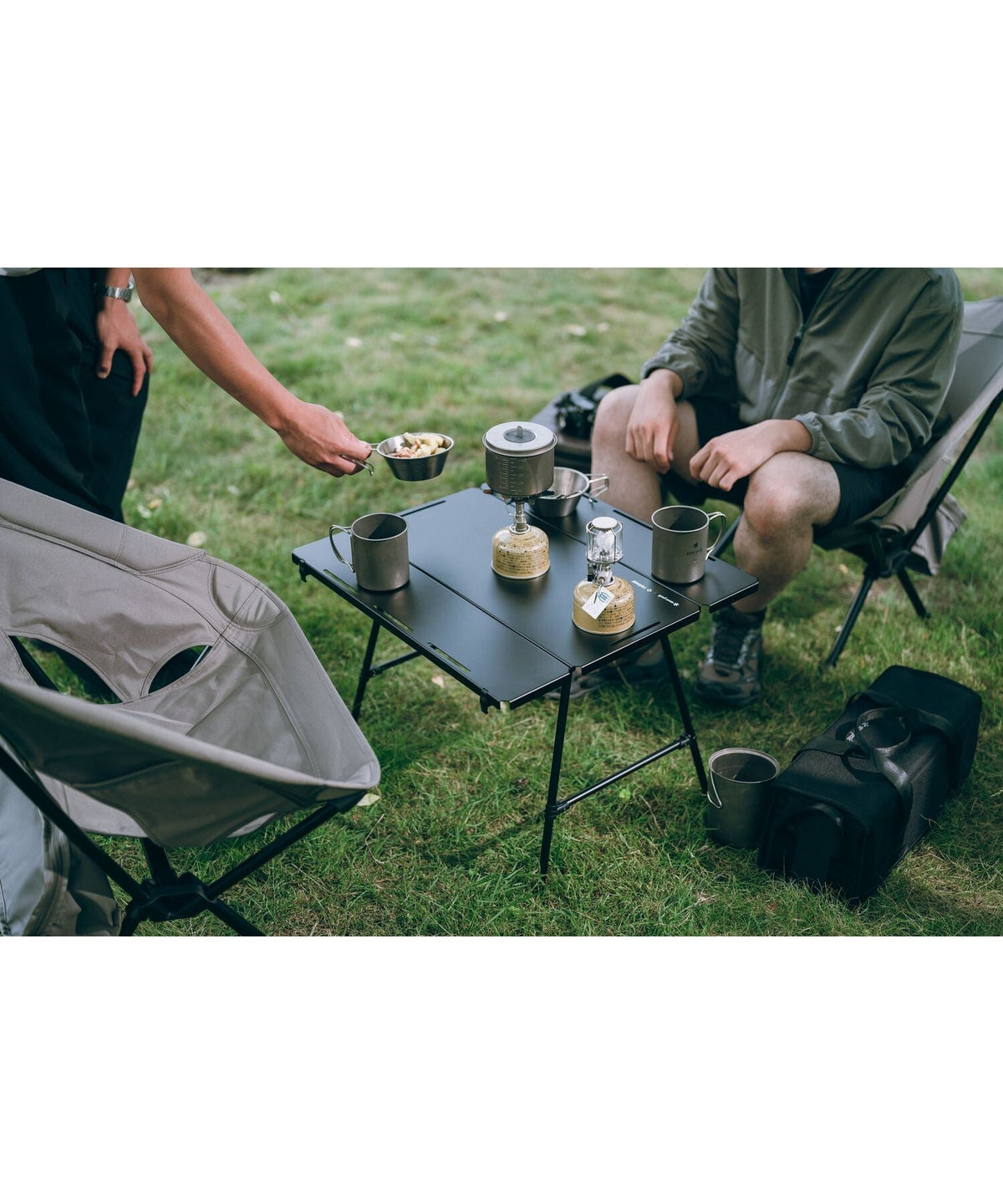 Noga Table, Black, in use as a shared table at camp