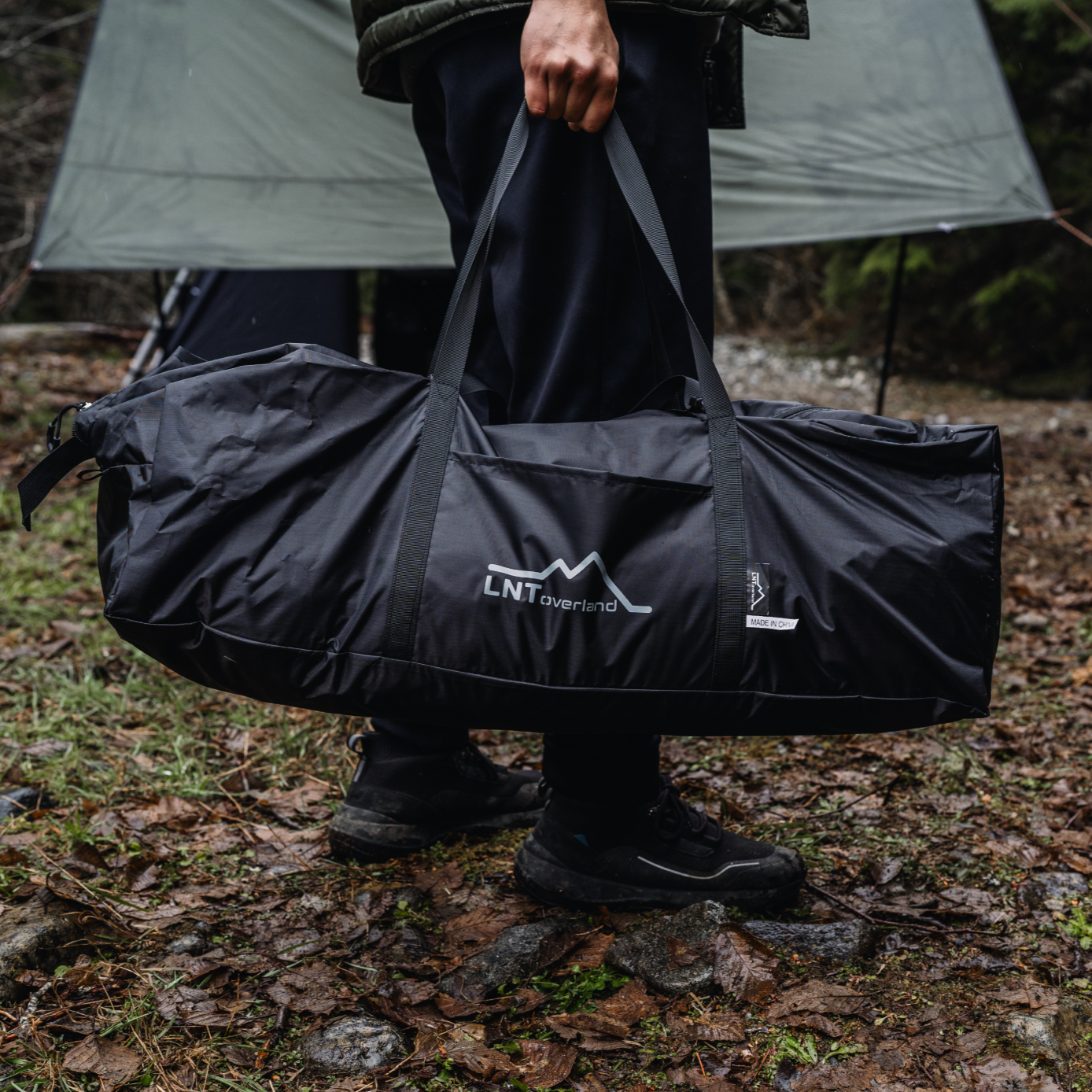 LNT Overland's ES Awning Screen is in a carry bag and a person is holding it easily.