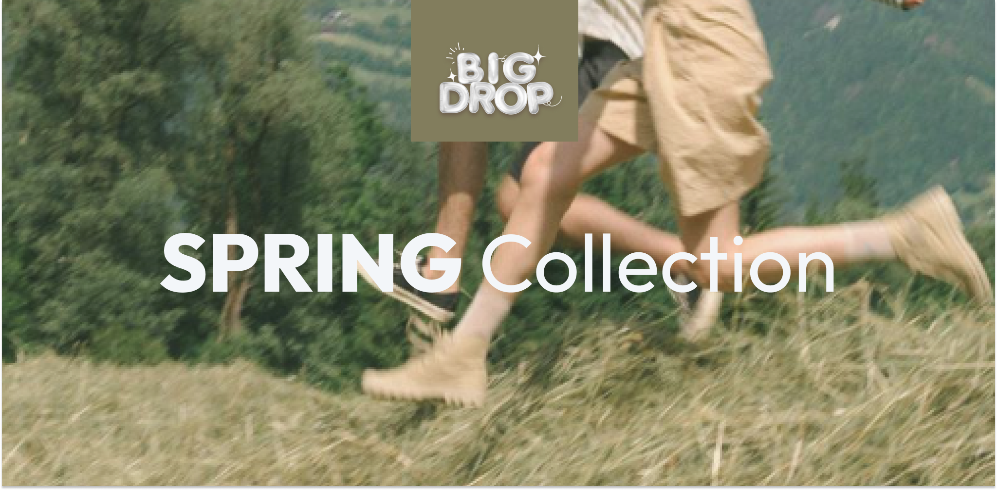 Two people running on a grassy hill with 'Big Drop' branding and 'Spring Collection' text.