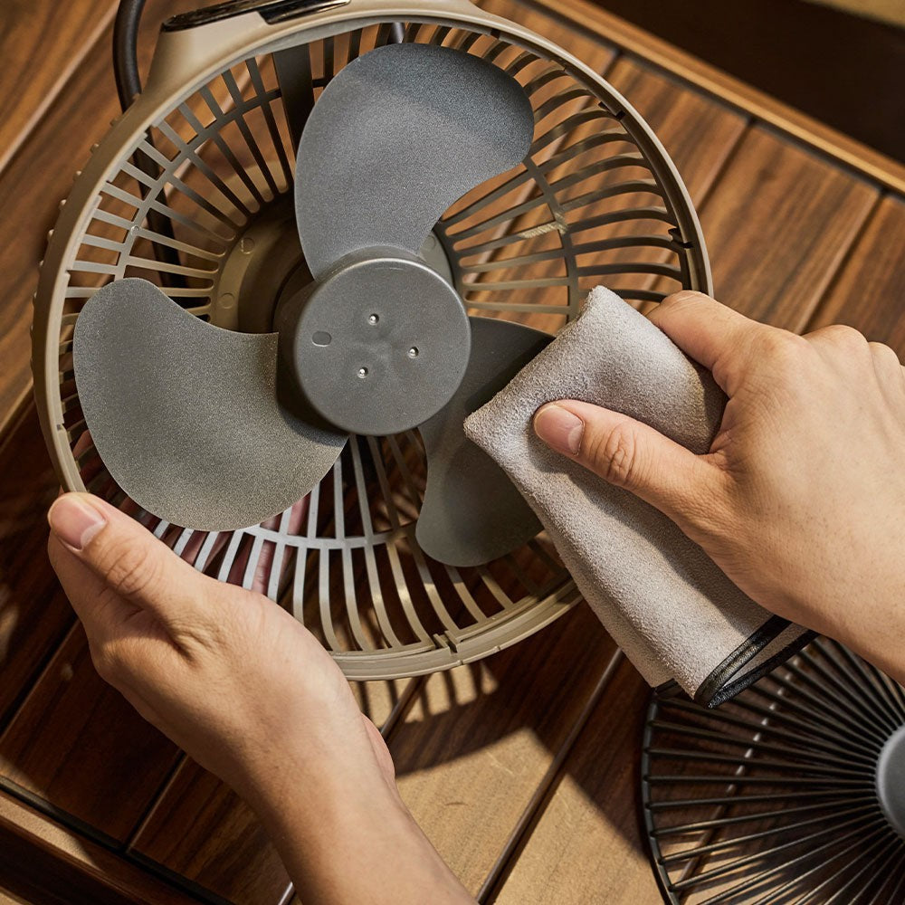 Hands wiping the fan blades of the V1040 with the front cage removed