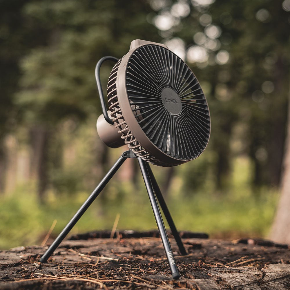 V600+ fan running cordless on a tree stump at a forest campsite