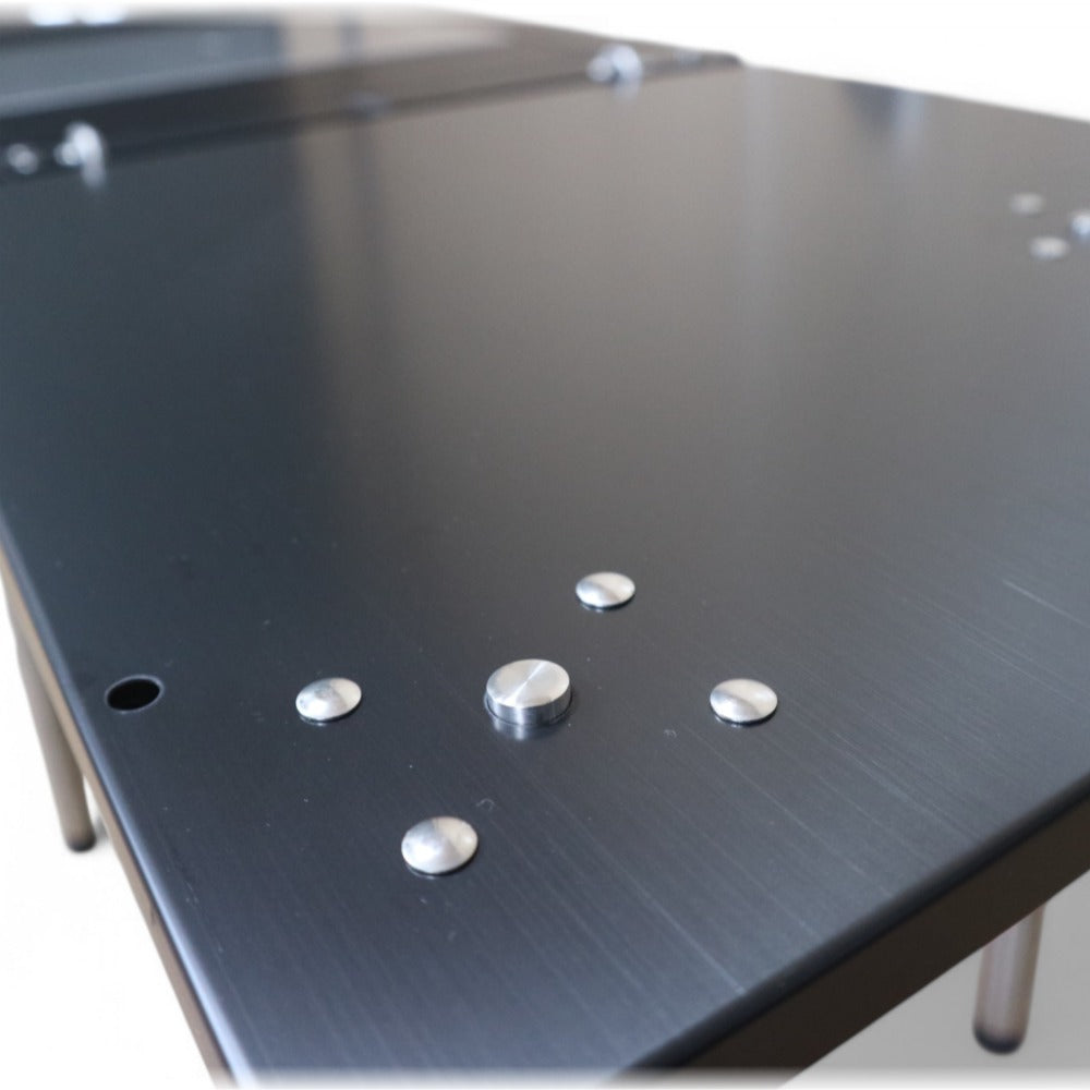 Close-up of the matte-black corner table top and the standardised IGT side holes along its edge.