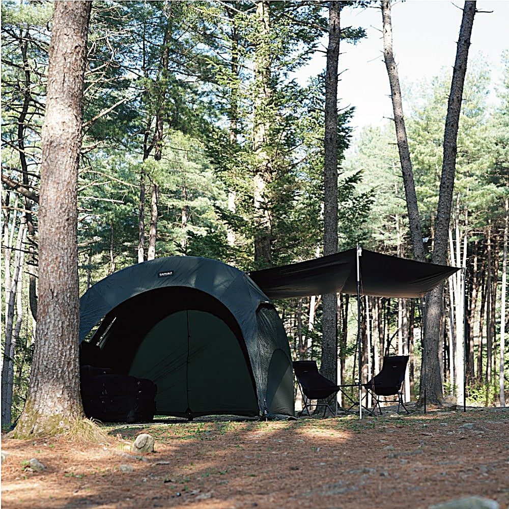 Gopamir T720+ Side Tarp shading a seating area beside the black dome tent under towering forest pines