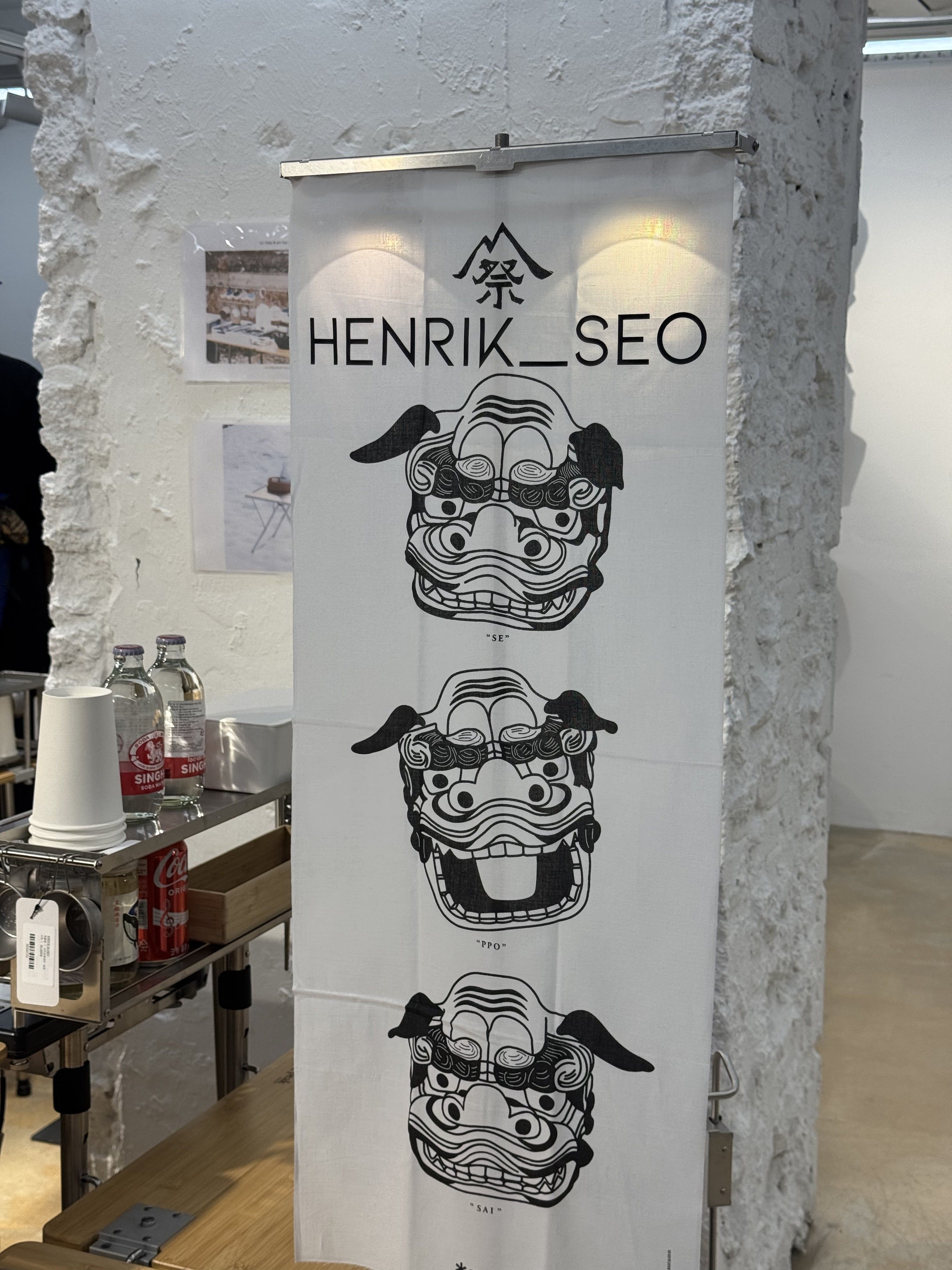 HR Tenugui Lantern Hanger displaying a Henrik Seo tenugui at a storefront