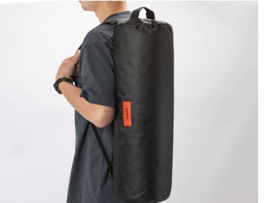 Person carrying the packed cot case over one shoulder