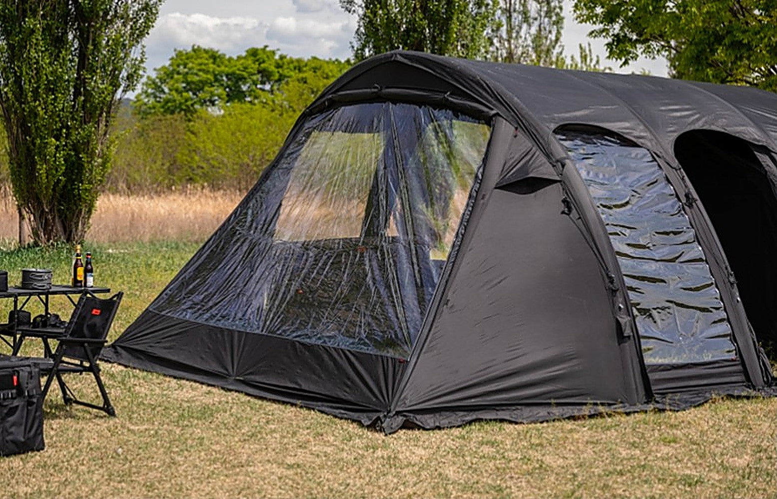 Ghost Phantom Air tent with the TPU Side Extension Set fitted, clear panels catching light on a grassy campsite