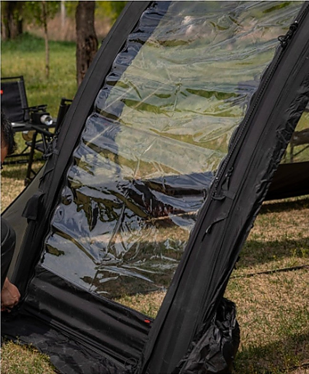 Camper attaching the clear TPU window panel of the Ghost Phantom Air side extension at a grassy campsite