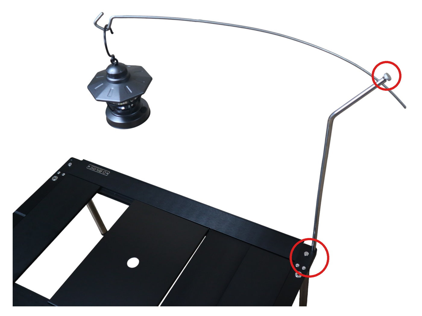Lantern hanger bolted to a Biloc table, both bolt points circled: arm-to-post screw and post-through-table bolt.