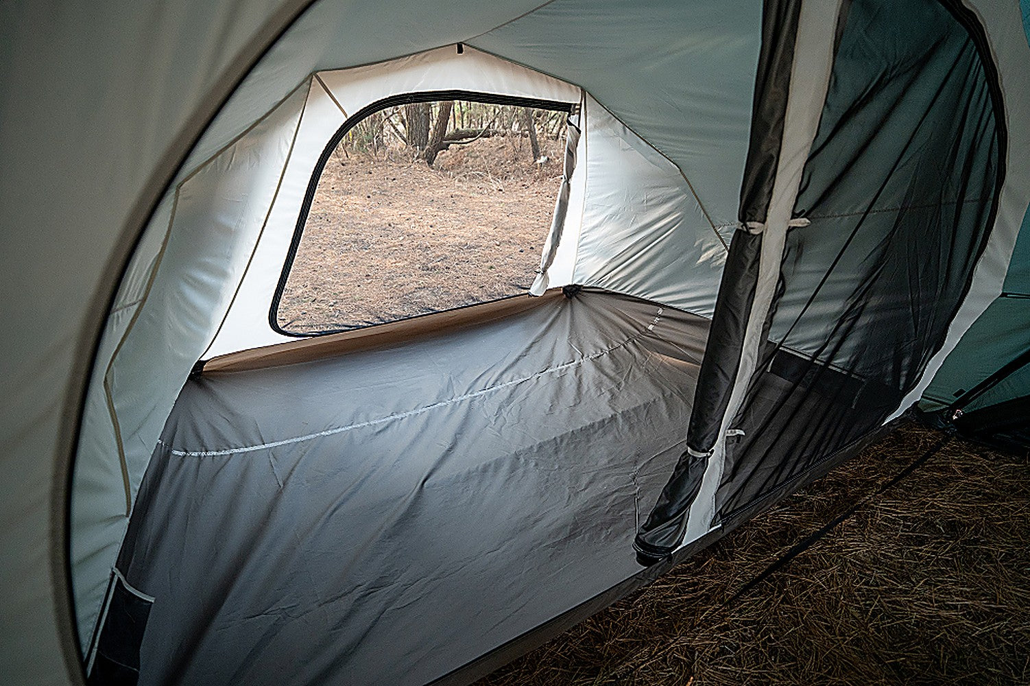 Interior of the empty inner tent showing the rear mesh window with its roll-up fabric cover open to the outdoors