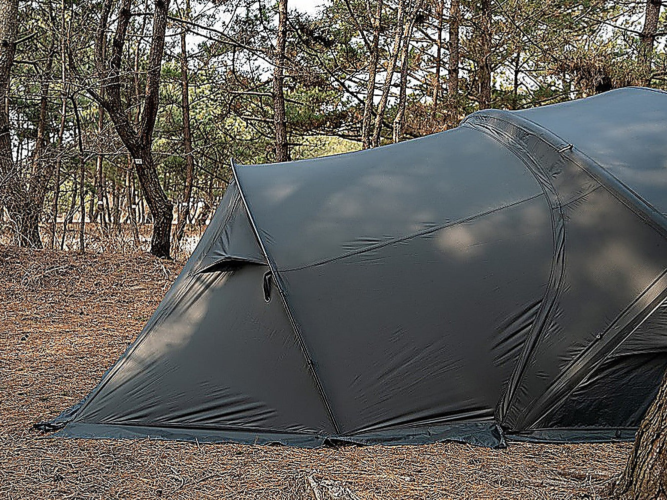 The Shelter GM vestibule attached to the front of the shelter, shown outdoors in a pine forest