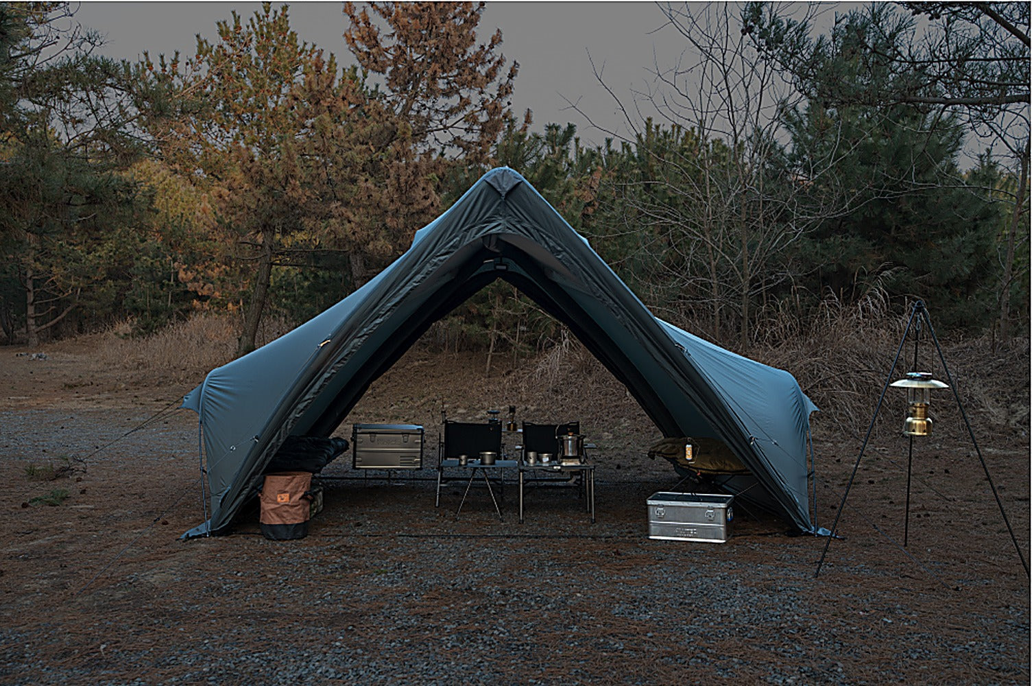Twilight exterior of the Super Position MGX-600 pitched in a forest clearing with the air-frame canopy and A-frame poles