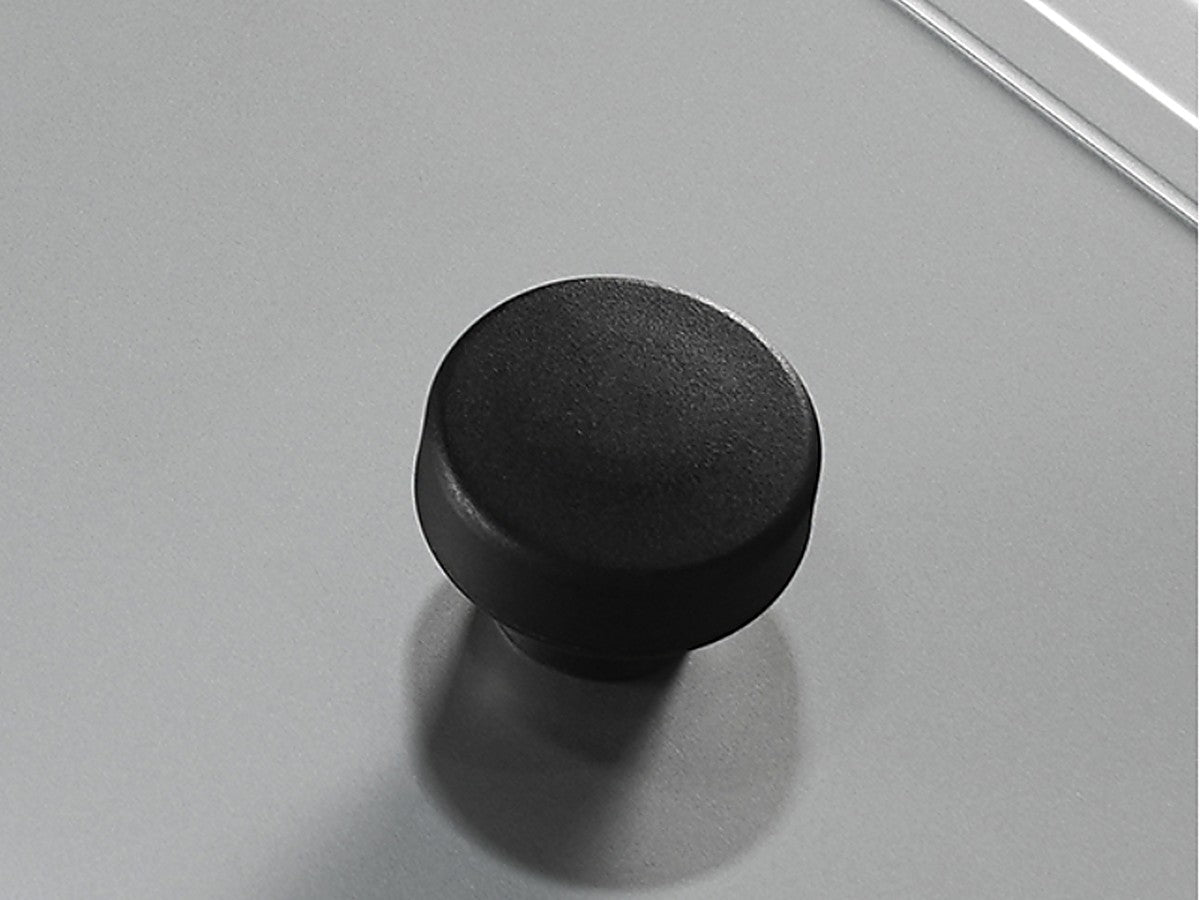 The black synthetic resin knob bolted through the centre of the stainless steel cover