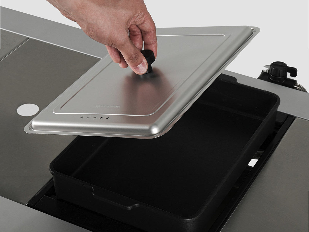 A hand lifting the cover clear of the hot pot pan to check what is cooking