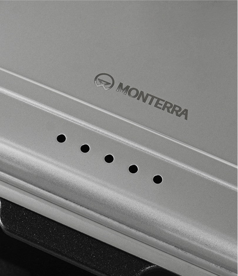 Close-up of the five steam vents and the engraved Monterra mark on the cover rim