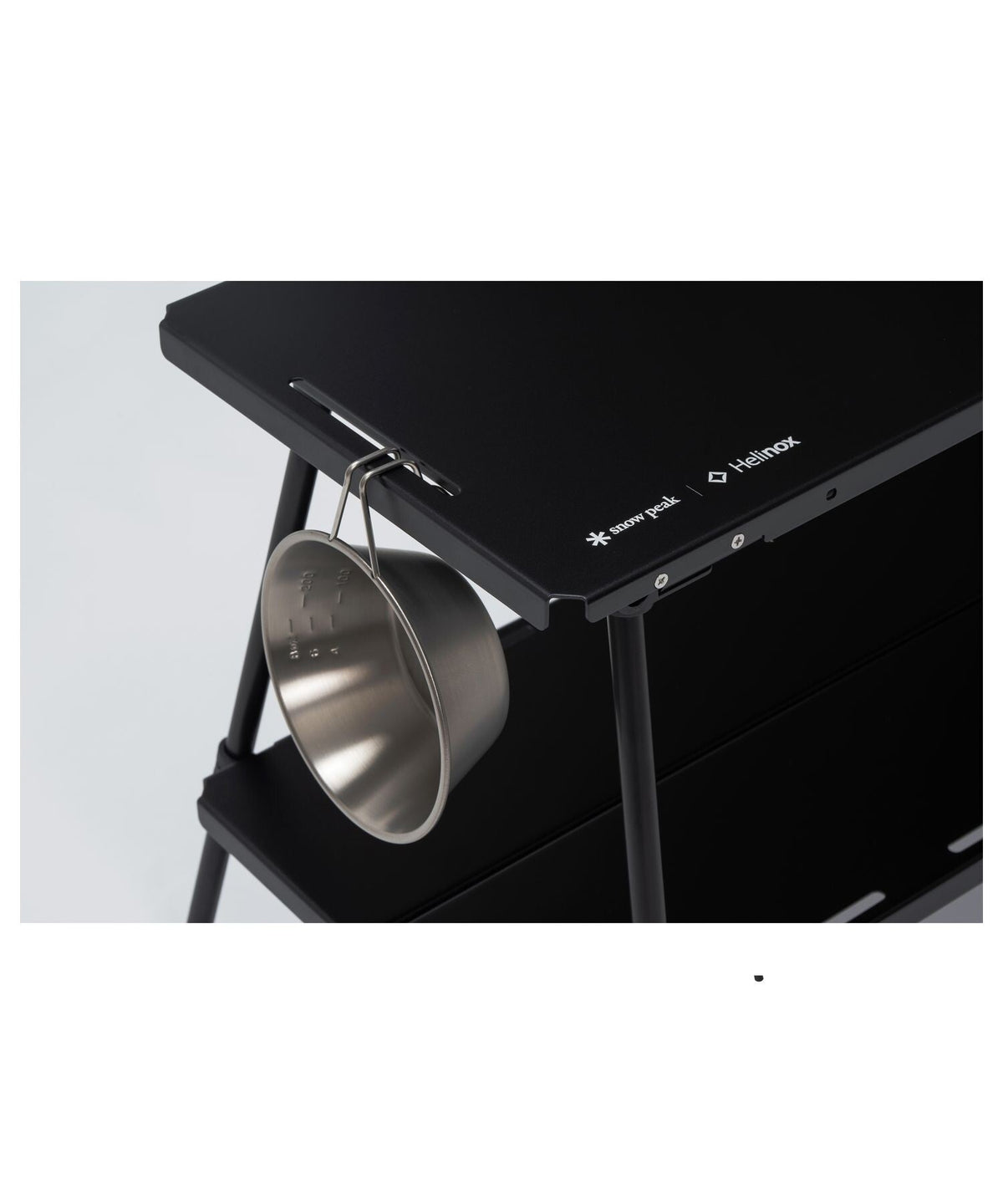 Noga Table, Black, a sierra cup hung from a perimeter hanging slit