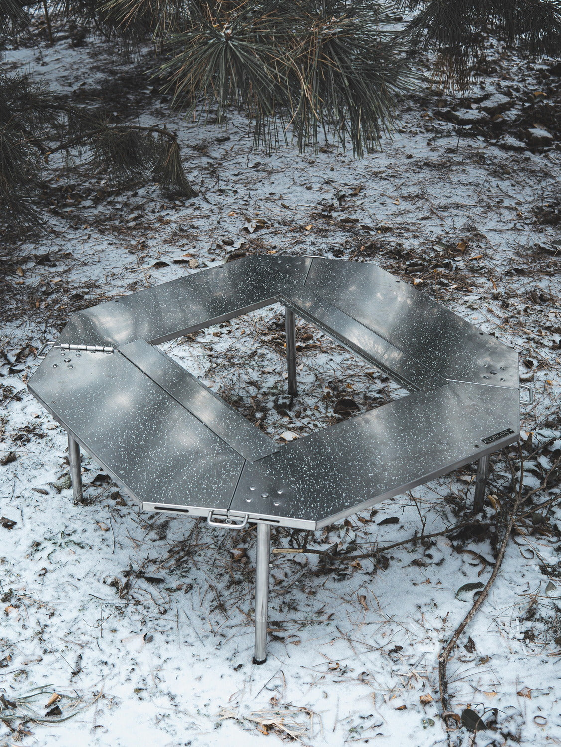 Biloc Octa IGT fire ring table set up on snowy ground, octagonal top with open centre bay