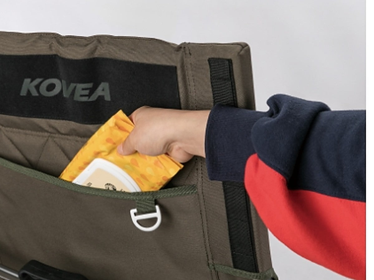 Hand sliding an item into the rear backrest pocket