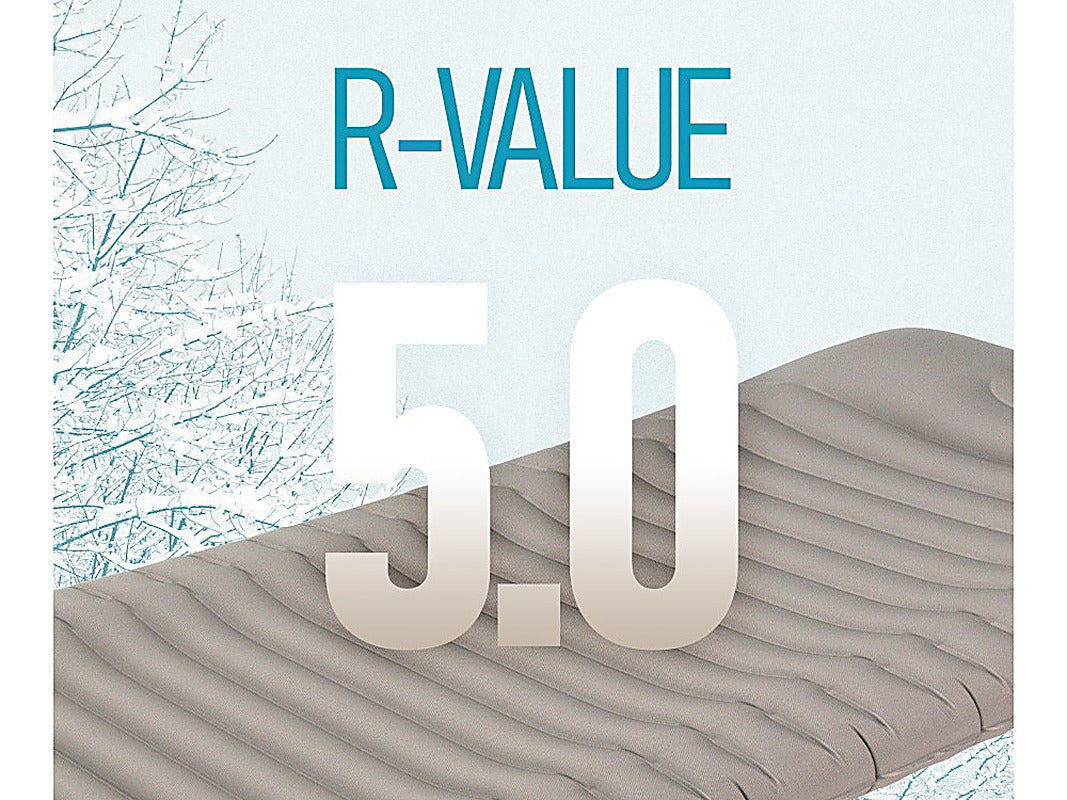 The pad beside snow-covered branches with an R-VALUE 5.0 graphic across the frame.
