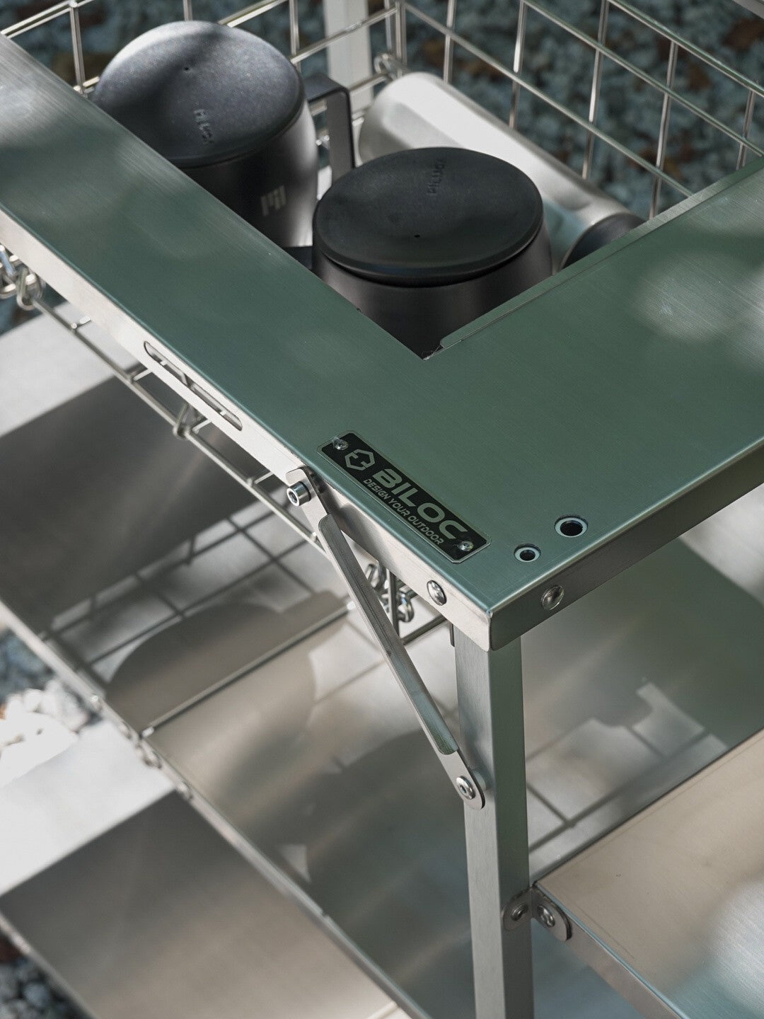 Corner detail of the Biloc Stella shelf brushed stainless top and folding bracket