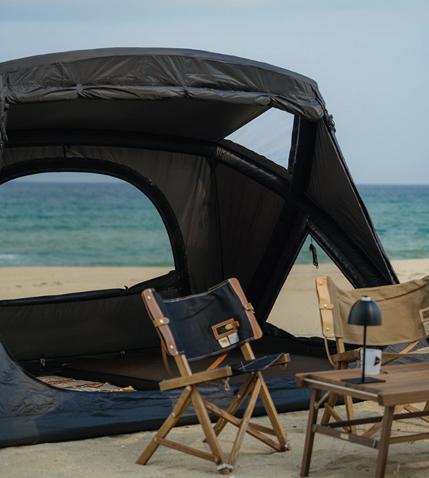 theEarth GEO AIR4 Tent, Black, front interior view with camp chairs on a beach